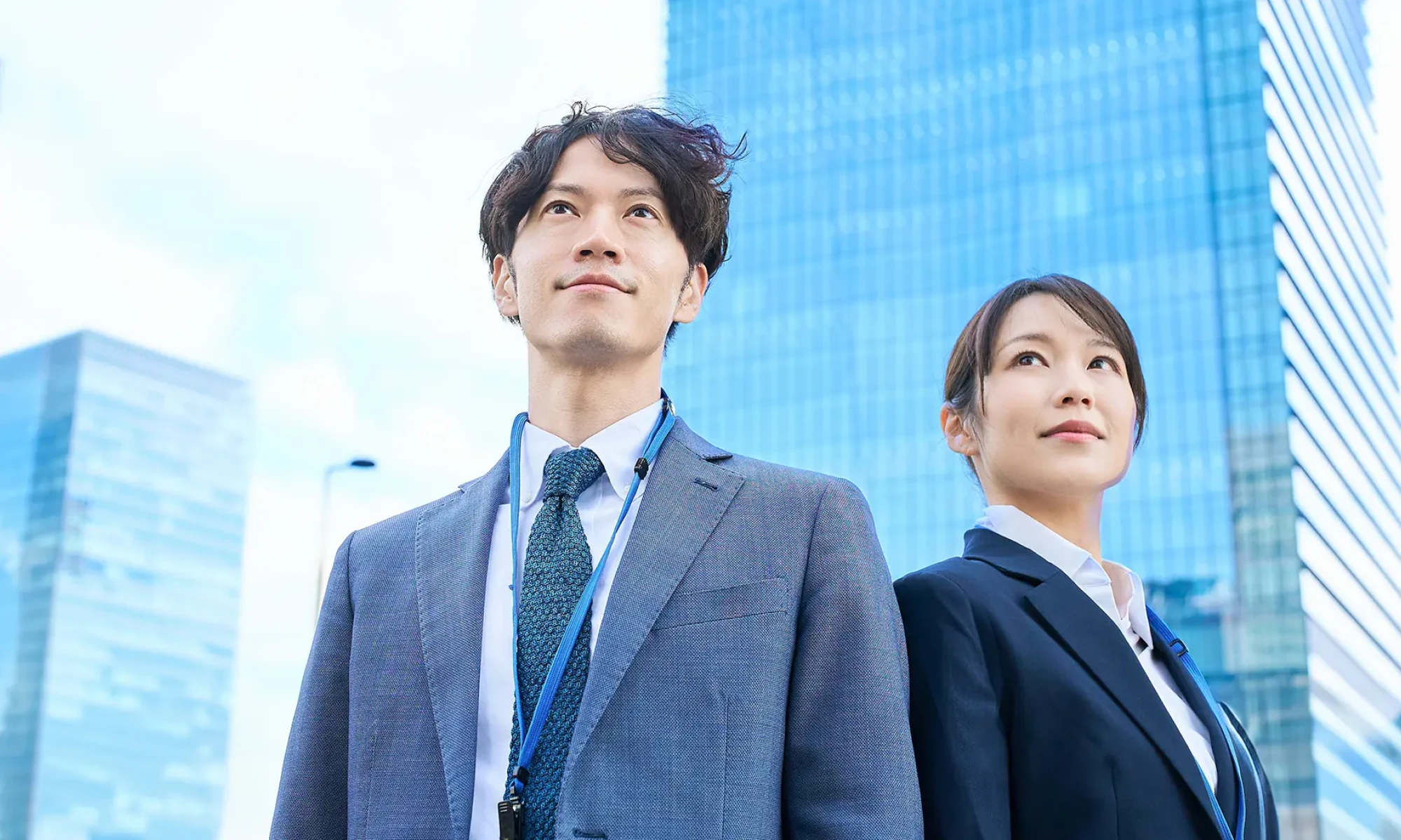 空を見上げる社会人男女